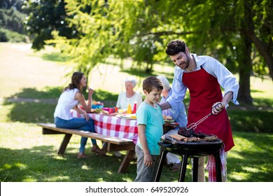 Father and son barbequing in the park during day - Powered by Shutterstock