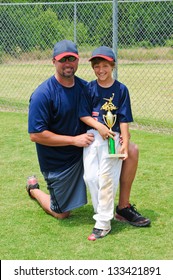 Father And Son Baseball Portrait Holding Trophy.