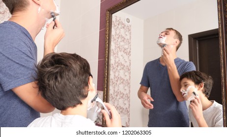 Father and son in the bathroom in the morning, little boy copies his father shaving. - Powered by Shutterstock