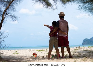 Father And Son With The Beach,Son Show His Hand And Tell Father For Looking View The Sea.