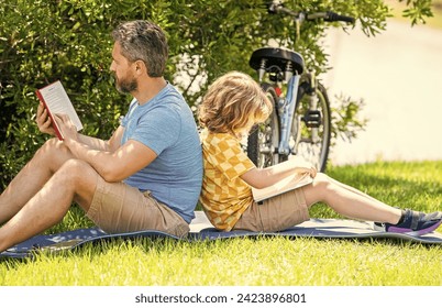 Father and son bonding through outdoor reading. Father and son reading time. Dad and child reading book together. child son learning with dad outdoor. storytime in the great outdoors - Powered by Shutterstock