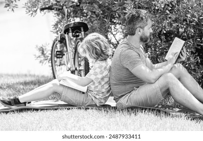 Father and son bonding through outdoor reading. Father and son reading time. Dad and child reading book together. child son learning with dad outdoor. storytime in the great outdoors - Powered by Shutterstock