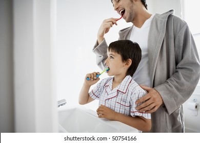 Father and Son Brushing Teeth in bathroom - Powered by Shutterstock