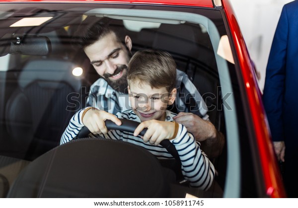 Father and\
son buying a new car at the car\
showroom.