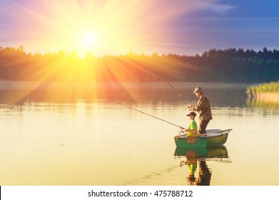 Father And Son Catch Fish From A Boat At Sunset