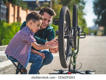 The father and son checking the bicycle chain - Powered by Shutterstock