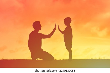 Father son child relationship talking communicating. Young dad parenting his child giving him high-five encouragement. 