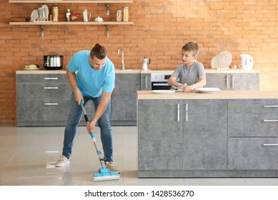 Father and son cleaning kitchen together - Powered by Shutterstock