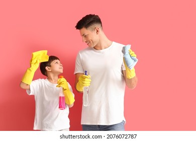 Father And Son With Cleaning Supplies On Color Background
