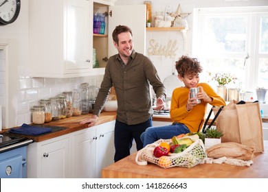 Father And Son Coming Home From Shopping Trip Using Plastic Free Bags Unpacking Groceries In Kitchen - Powered by Shutterstock