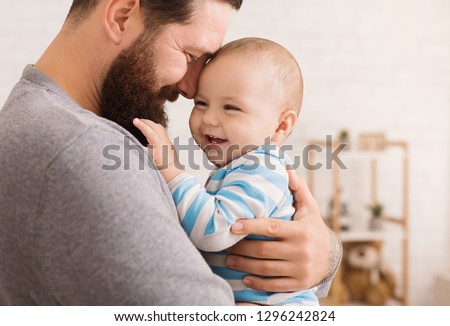 Father and son connection. Dad embracing his adorable baby, closeup portrait