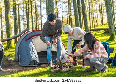 Father, son and daughter making a bonfire in the forest next to camping tent - Powered by Shutterstock