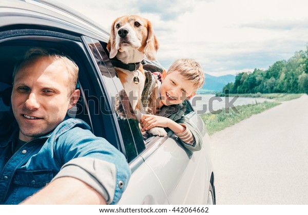 Father with son\
and dog look from the car\
window