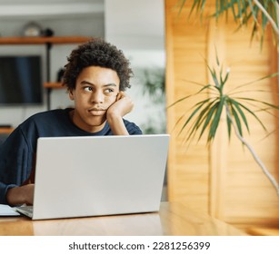 Father and son doing homework with laptop fighting and arguing over learning at home. Father and teenage son using laptop. Boy and dad sitting at home working with notebook, boy being bored looking  - Powered by Shutterstock