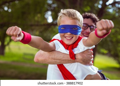 Father And Son Dressed As Superman In The Garden