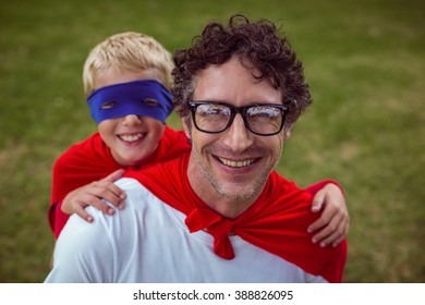 Father And Son Dressed As Superman In The Garden