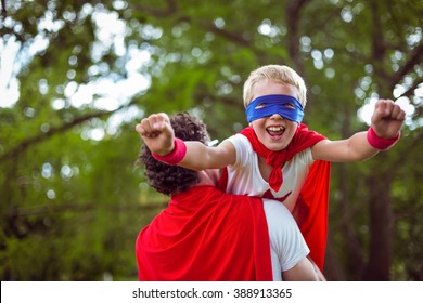 Father And Son Dressed As Superman In The Garden