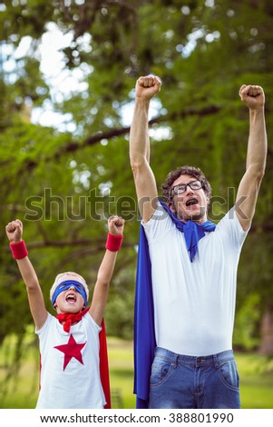 Father and son dressed as superman in the garden