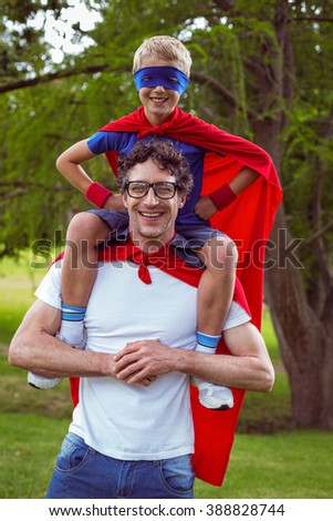 Father and son dressed as superman in the garden