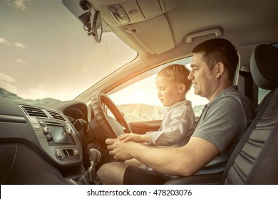 Father And Son Driving In Car