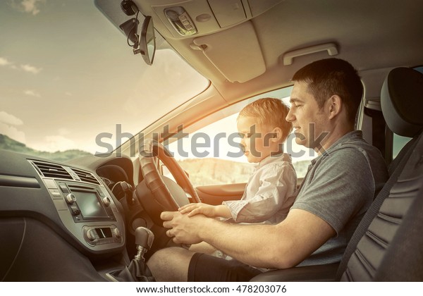 Father and son driving in\
car