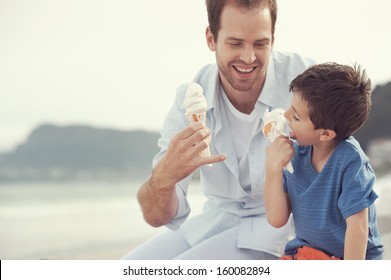 Father and son eating icecream together at the beach on vacation having fun with melting mess - Powered by Shutterstock