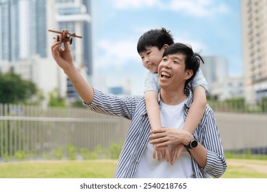 Father and son enjoy playful bonding in the garden, laughing and sharing moments with a toy airplane. A joyful outdoor family activity celebrating love, learning, and togetherness. - Powered by Shutterstock