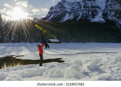 Father And Son Enjoying The Snow On A Sunny Day At Lake Louise