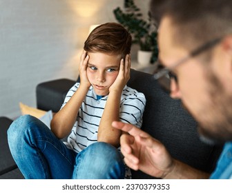 Father and son fighting and arguing over learning at home. Boy and dad sitting at home conflict and domestic problems - Powered by Shutterstock