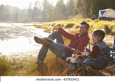 Father and son fishing by a lake, dad looks to camera