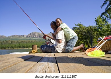 Father And Son Fishing Off Dock