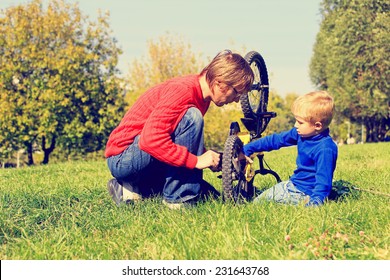 father and son fixing bike in the park - Powered by Shutterstock