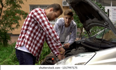 Father and son fixing car, dad teaching teen boy to repair engine, role model - Powered by Shutterstock