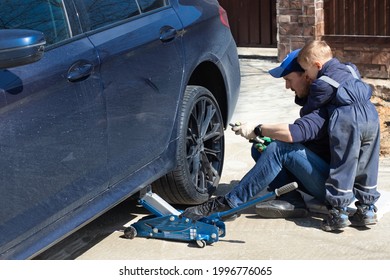 Father and son are fixing the car. The son helps the dad. Happy Father's Day. 