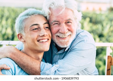 Father and son or grandfather and grandson together hug and enjoy with smile - cheerful different age caucasian people in outdoor - concept of ages and mixed generations men