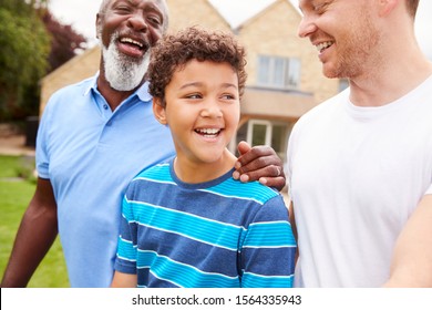 Father With Son And Grandfather From Multi-Generation Mixed Race Family Walking In Garden At Home