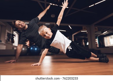 Father and son in the gym. Father and son spend time together and lead a healthy lifestyle. Man and boy are working out. Father and son are doing exercise. - Powered by Shutterstock