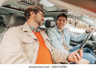 father and son have a discussion inside the car about navigation in smartphone - Powered by Shutterstock