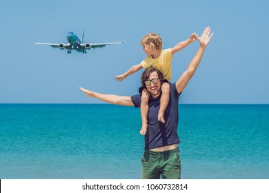 Father and son have fun on the beach watching the landing planes. Traveling on an airplane with children concept.