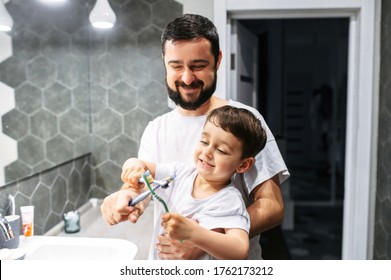 Father And Son Have A Fun While Brush Teeth Together, They Toothbrushes Fight