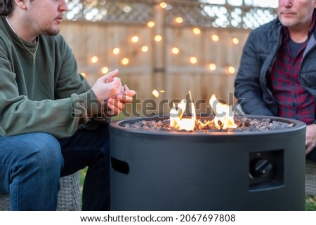 Father and son having a conversation while sitting around a fire