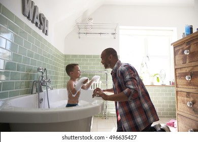 Father And Son Having Fun At Bath Time Together