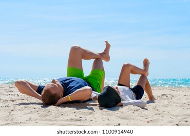 father and son having fun on the beach, laying on a beach. - Powered by Shutterstock