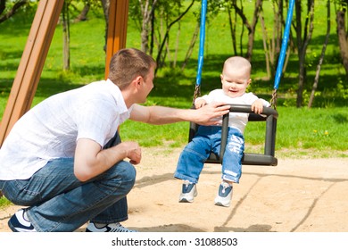 Father And Son Having Fun On The Playground