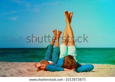 Vater und Sohn spielen zur Tageszeit am Strand. Die Menschen haben Spaß im Freien. Konzept des Sommerurlaubs und der freundlichen Familie.