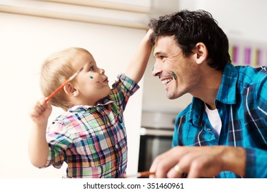 Father And Son Having A Good Time. Kid Is Painting Father's Face With Watercolors. Shallow Depth Of Field.