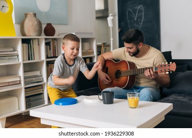 father and son having great time together at home. playing guitar and singing - Shutterstock ID 1936229308