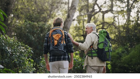 Father, son and hiking for fitness outdoor with backpacking support, trekking adventure and morning journey in forest. Senior man, family and comfort for travel exercise, bonding and explore nature - Powered by Shutterstock