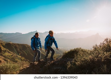 Father And Son Hiking In Scenic Mountains