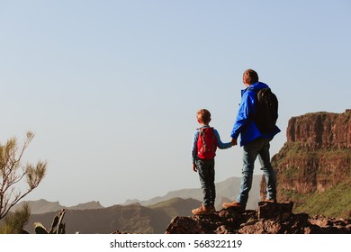 Father And Son Hiking In Scenic Mountains